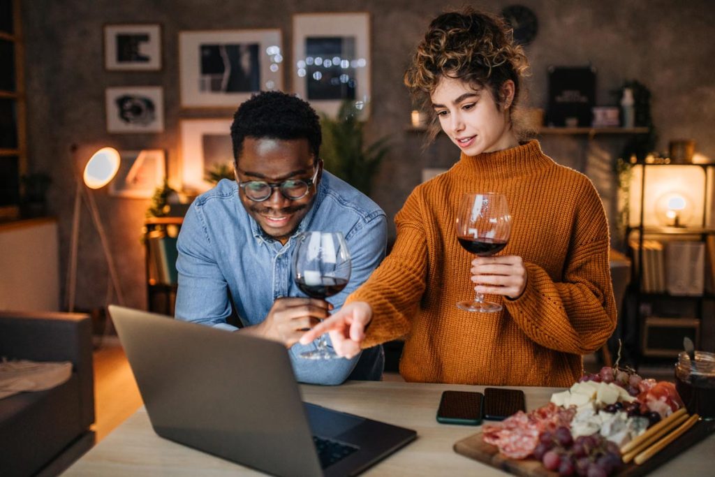 Young couple planning interior make over with glass of wine